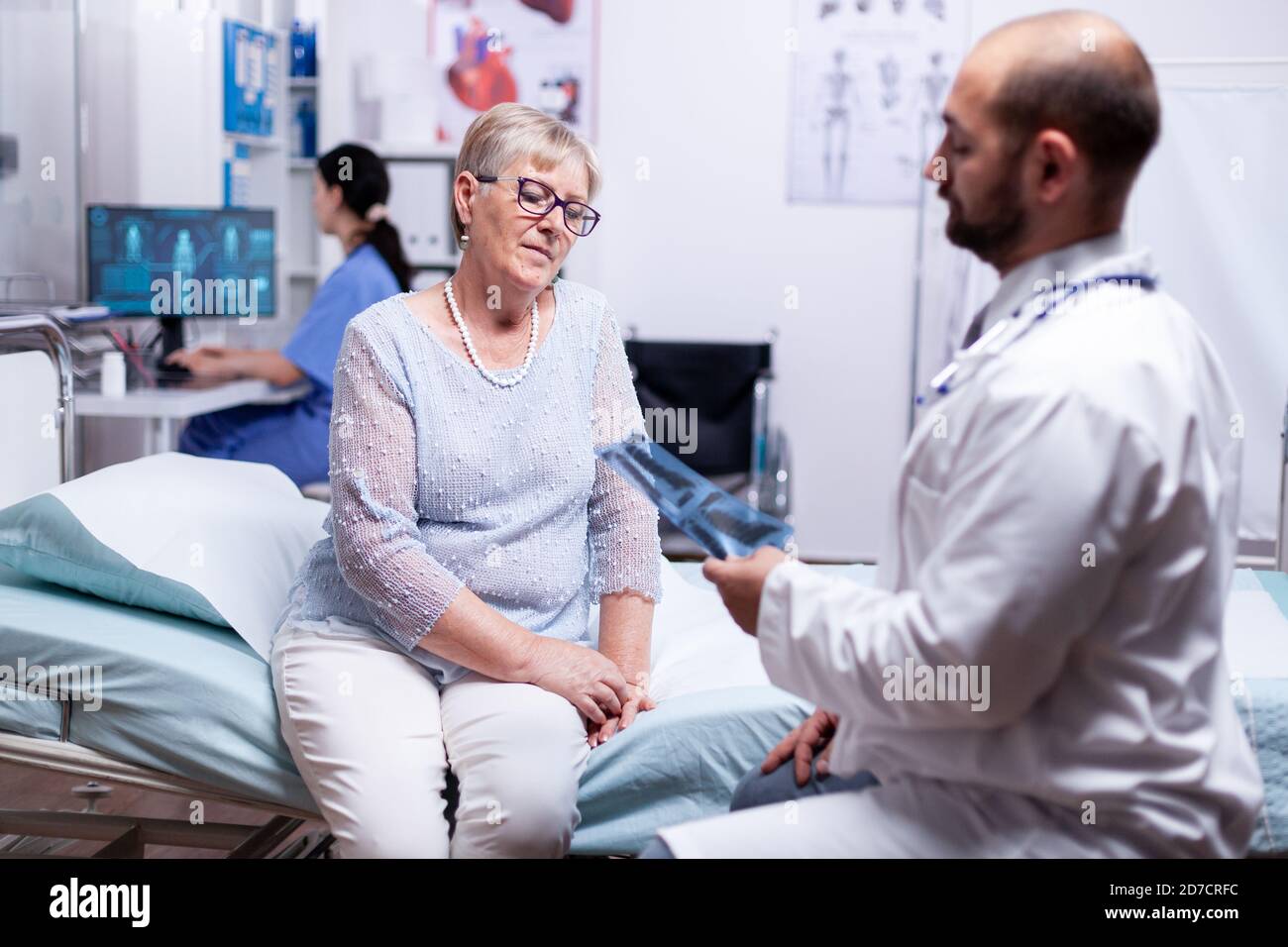 Médecin regardant la radiographie du patient tout en discutant du diagnostic dans la salle d'examen de l'hôpital. Santé système médical médical, traitement de prévention de la maladie, diagnostic de la maladie Banque D'Images