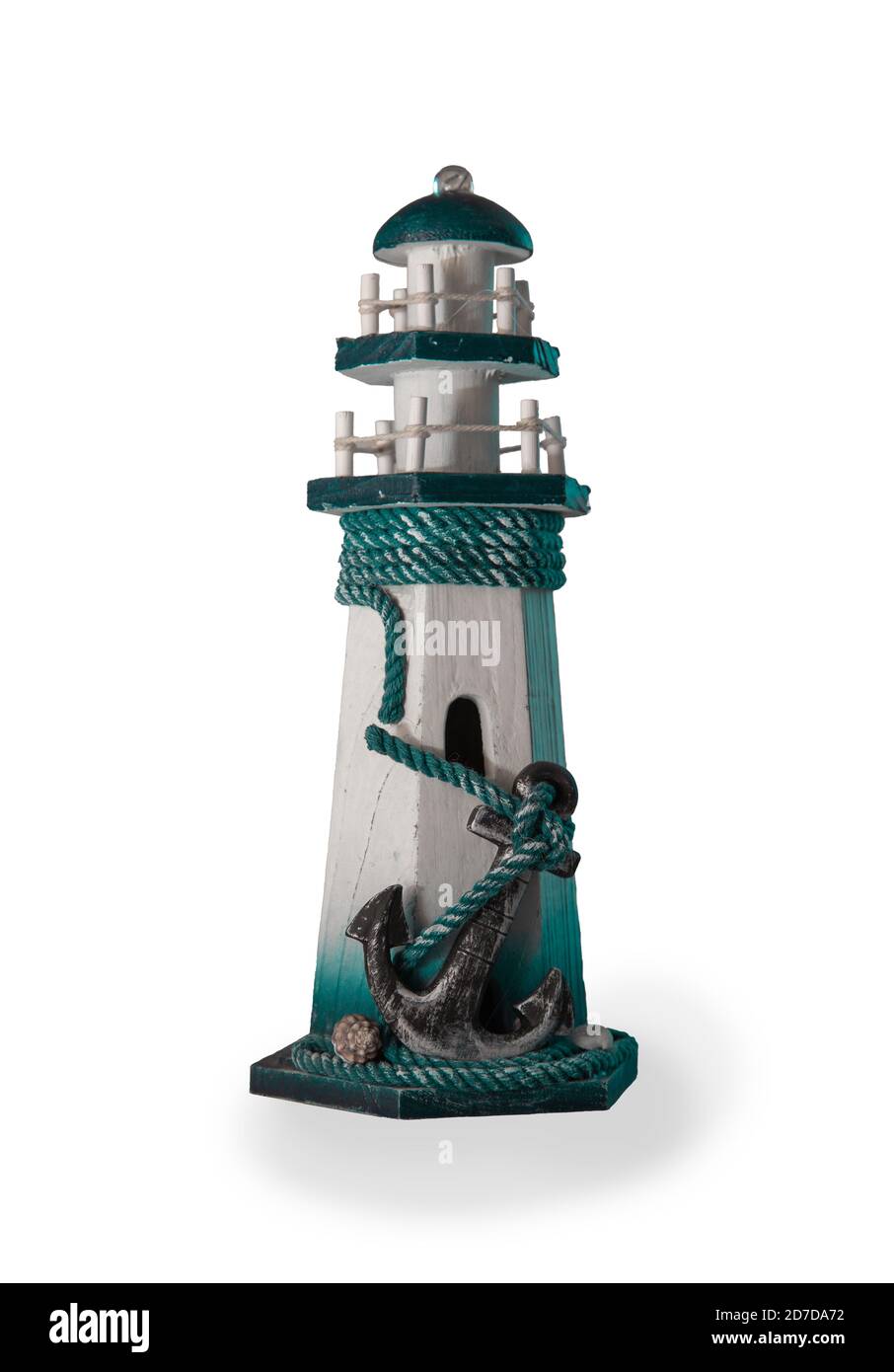 Une figurine sous la forme d'un phare avec une grande ancre au premier plan. Isoler. Banque D'Images