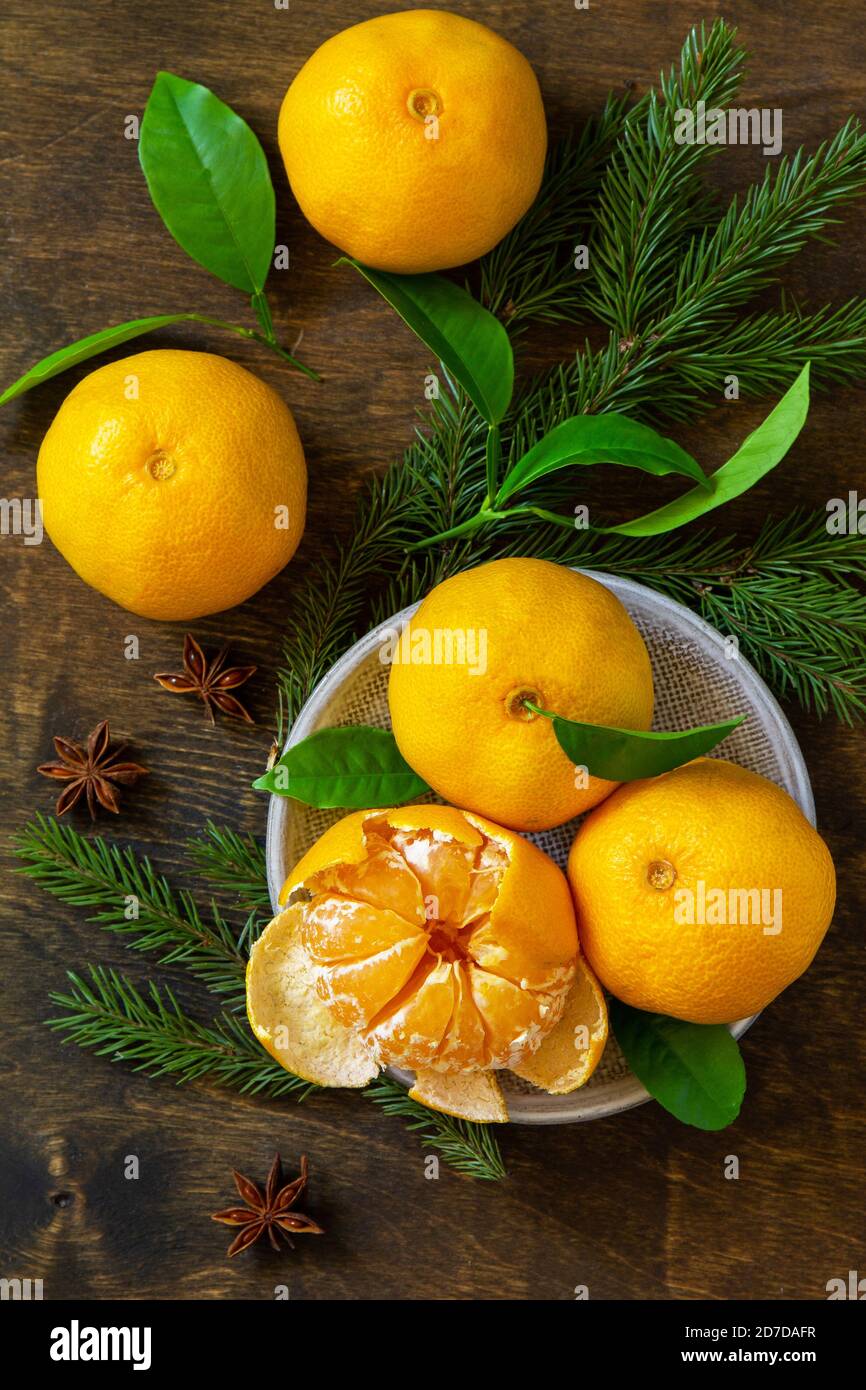 Fruits de l'hiver. Mandarines de clémentine fraîches et juteuses avec feuilles sur une table rustique en bois. Vue de dessus de l'arrière-plan de la mise à plat Banque D'Images