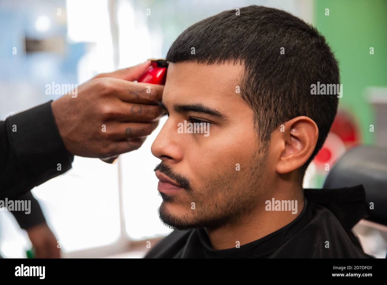 Un coiffeur afro-américain noir coupe et coupe les cheveux d'un homme  latino-américain hispanique avec un bouc et une moustache avec un rasoir  électrique dans un salon de coiffure Photo Stock - Alamy