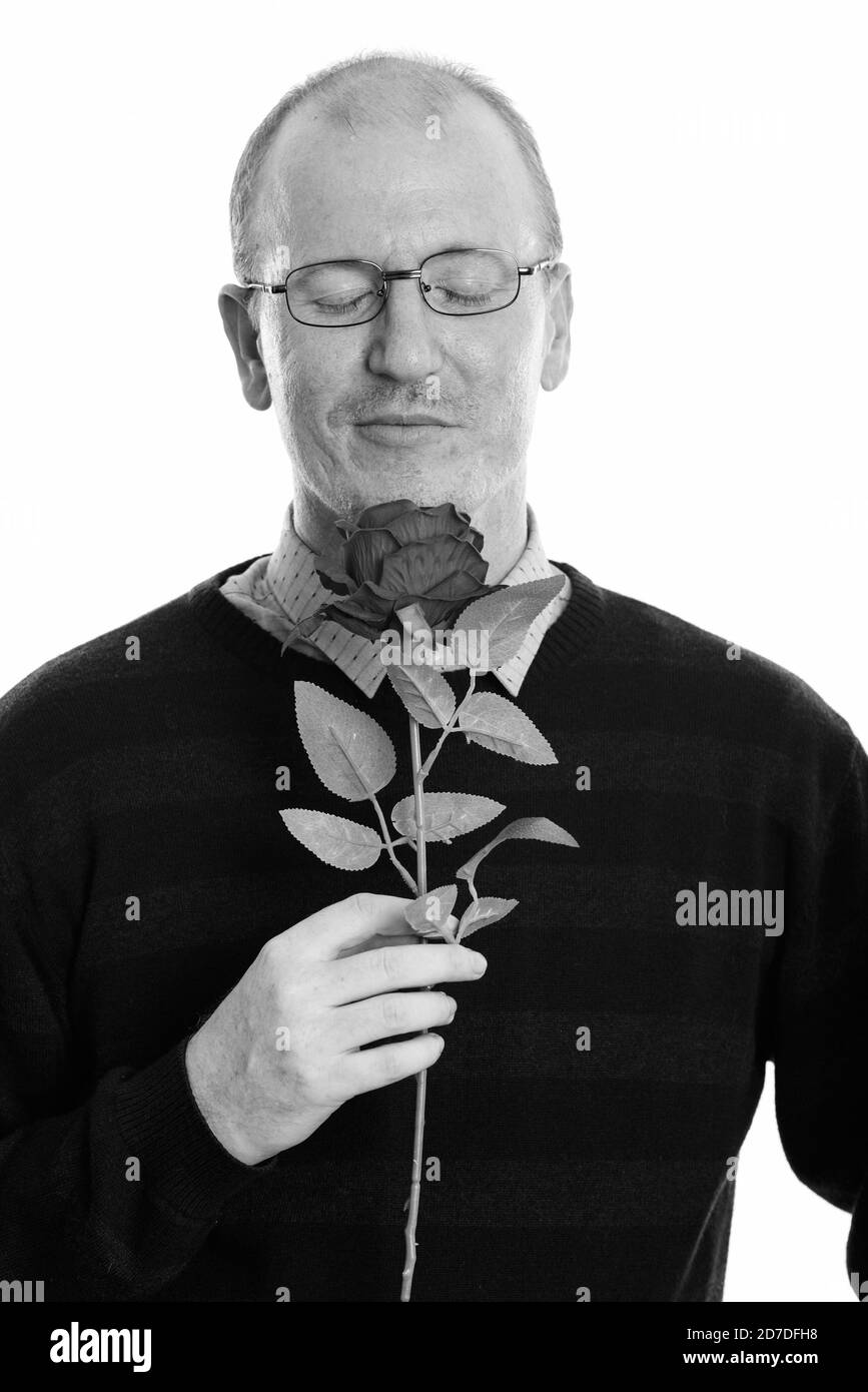 Photo studio de l'homme sentant la rose avec les yeux fermés prêt Pour la Saint-Valentin Banque D'Images