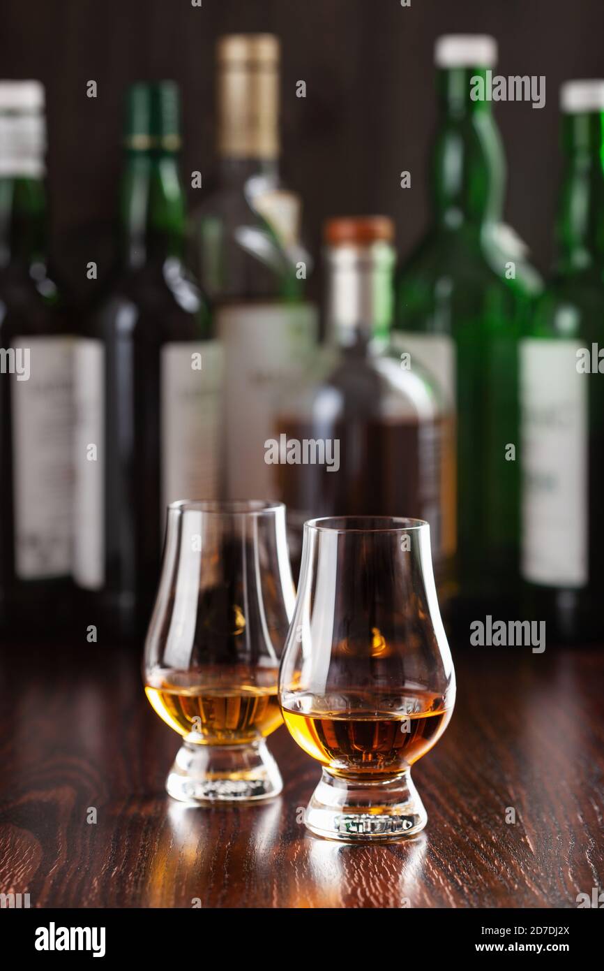 Bouteilles et verre de whisky Spirit brandy sur fond marron foncé Banque D'Images