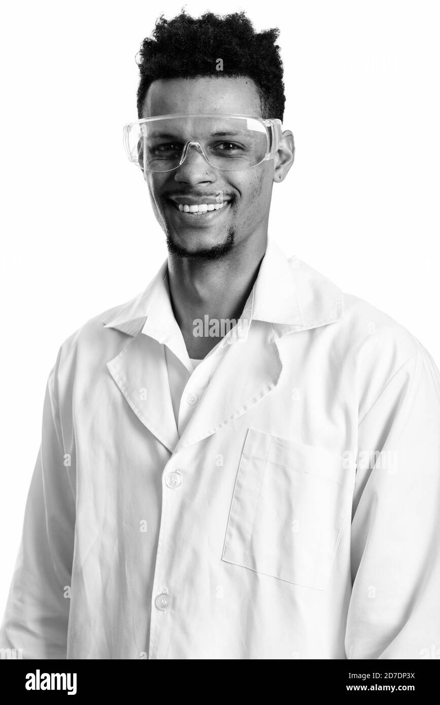 Studio shot of young happy African man smiling médecin tout en portant des lunettes Banque D'Images
