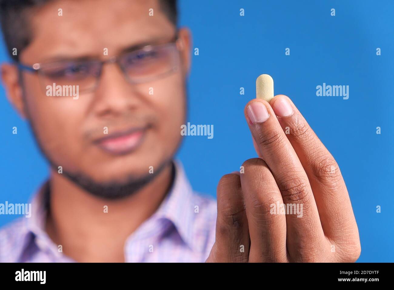 inquiet jeune homme main tenant la pilule Banque D'Images