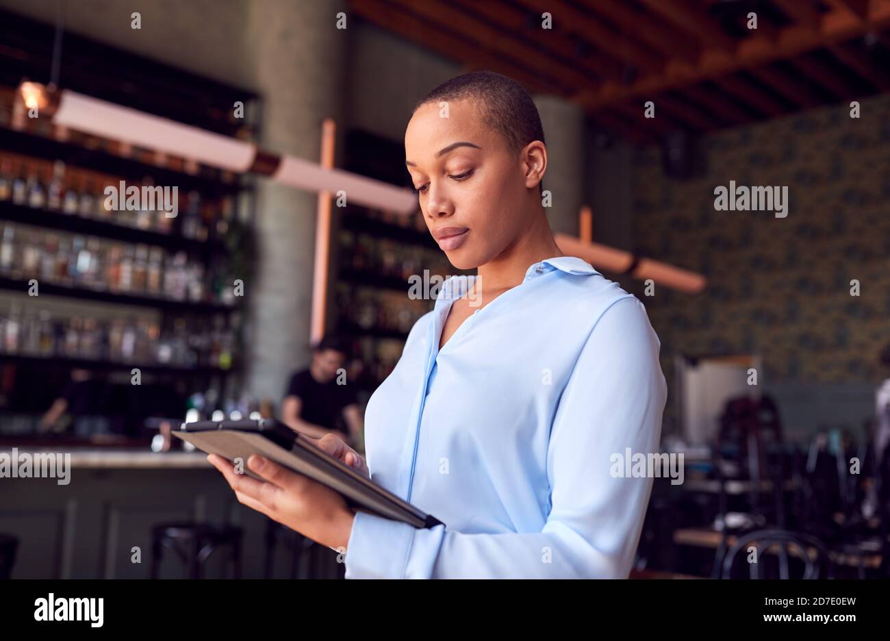 Femme confiante propriétaire du bar-restaurant debout près du comptoir de la tenue Tablette numérique Banque D'Images