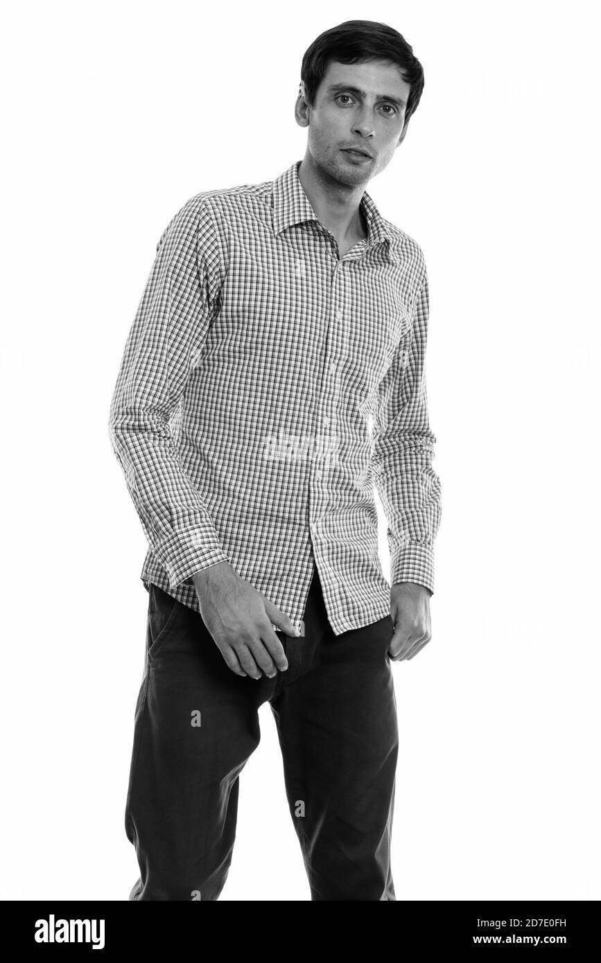 Studio shot of young handsome businessman standing tout en se posant Banque D'Images Studio shot of young handsome businessman standing tout en se posant Banque D'Images