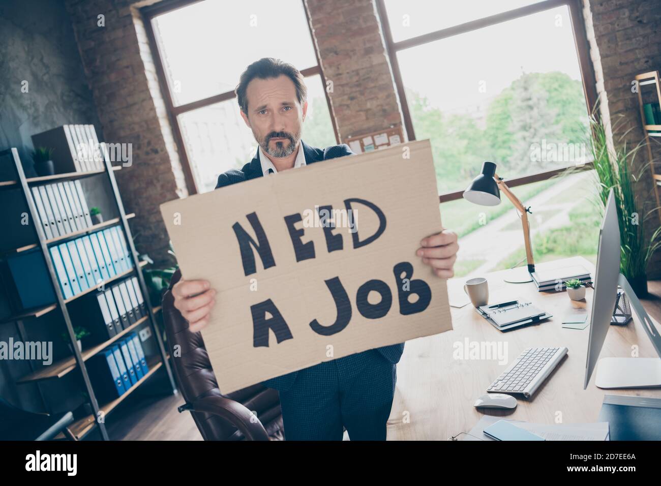 Plus de bossage. Photo de moody désespoir triste licencié travailleur mature gars Hold affiche chercher un nouvel emploi le dernier jour de travail lieu de travail tiré mauvais Banque D'Images