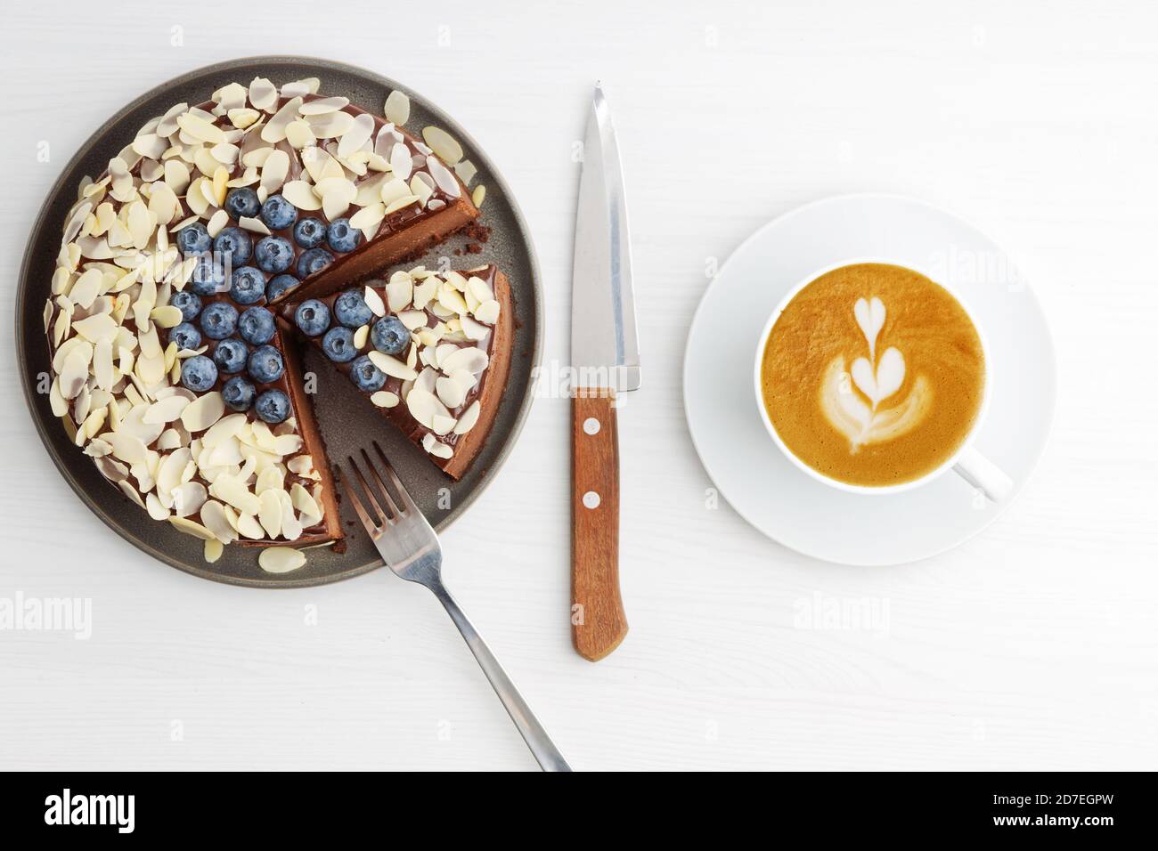 Cheesecake au chocolat maison avec myrtilles et tranches d'amande sur table en bois blanc. Vue de dessus. Banque D'Images