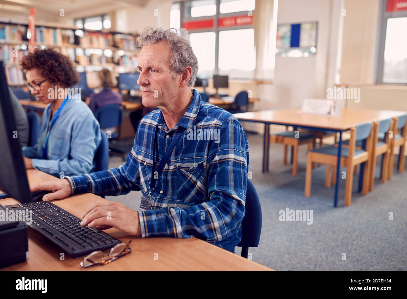 Groupe d'étudiants adultes en classe travaillant à l'informatique Dans la bibliothèque du Collège Banque D'Images