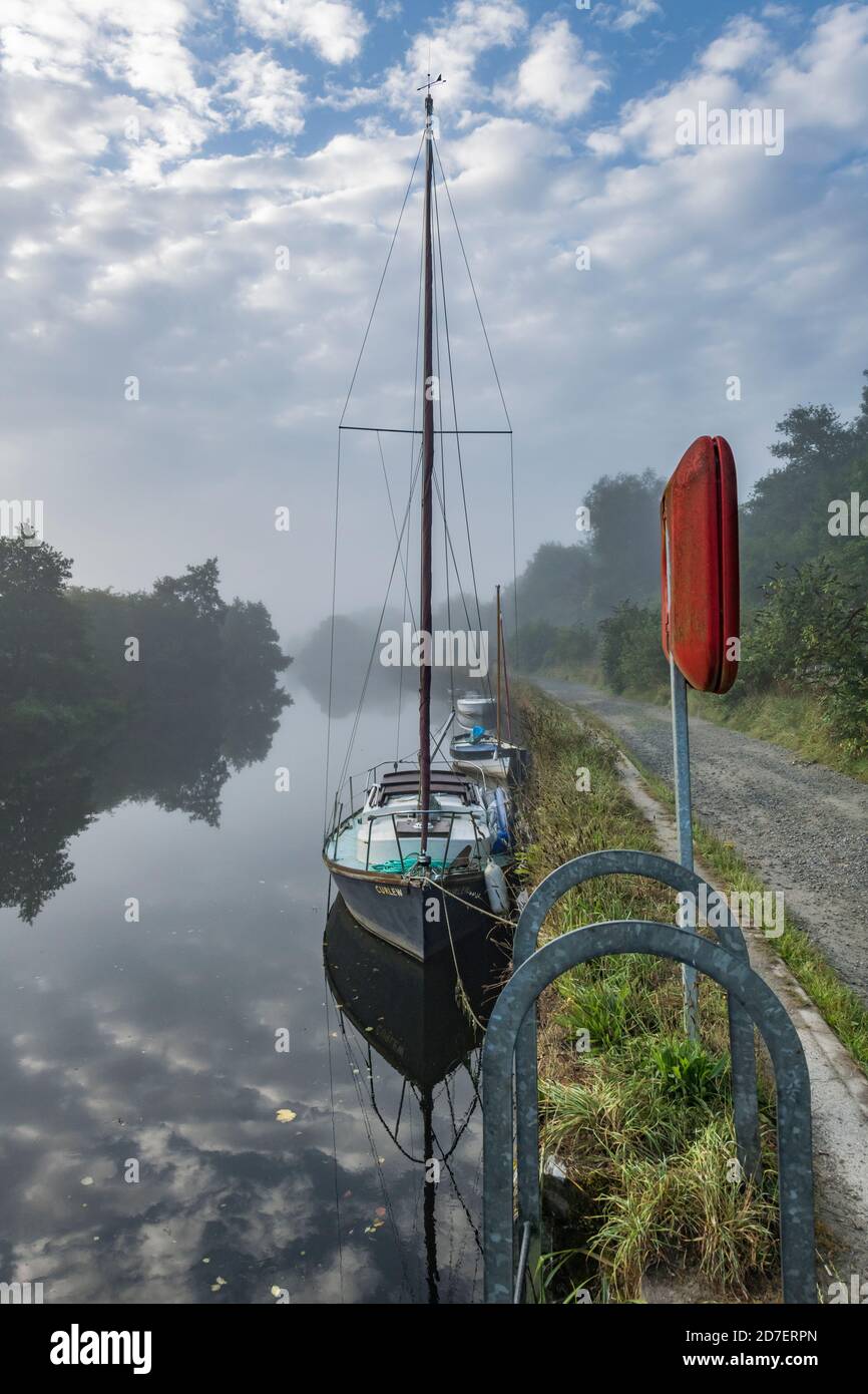 Prise de vue brumeuse en début de matinée d'un bateau à voile amarré le long du quai de la rivière Fowey à Lostwithiel, en Cornouailles. Banque D'Images