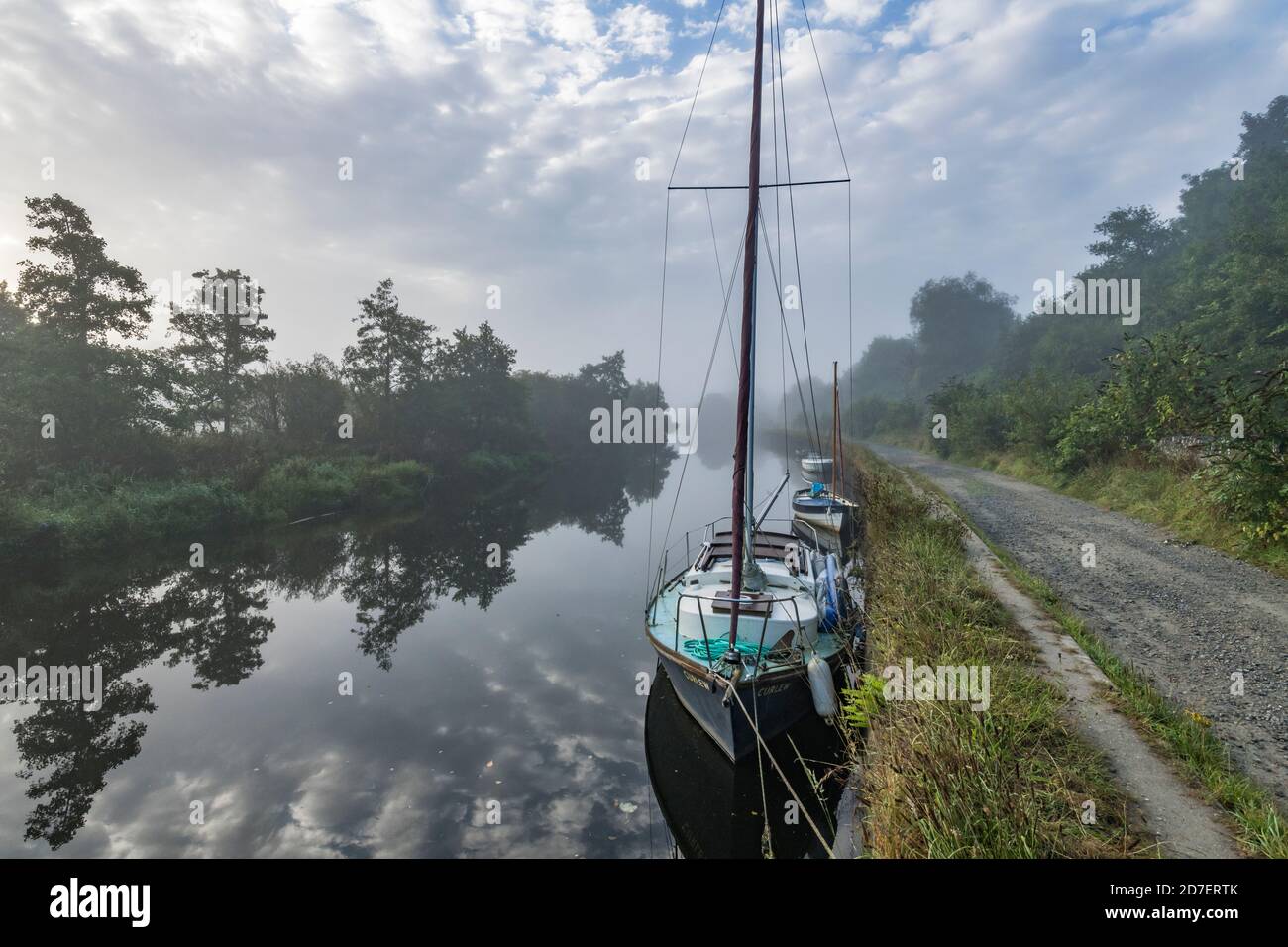 Prise de vue brumeuse en début de matinée d'un bateau à voile amarré le long du quai de la rivière Fowey à Lostwithiel, en Cornouailles. Banque D'Images