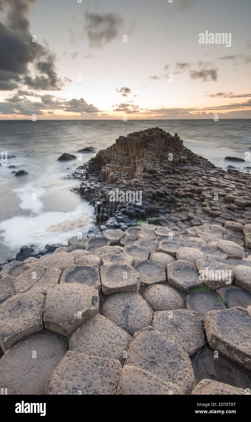 Coucher de soleil sur la chaussée des géants, site classé au patrimoine mondial de l'UNESCO de quelque 40,000 colonnes hexagonales sur la côte d'Antrim en Irlande du Nord. Banque D'Images