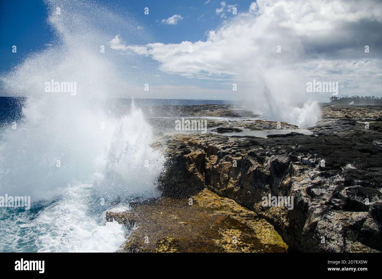 Alofaaga souffles sous la lumière du soleil et un ciel bleu nuageux Aux Samoa Banque D'Images