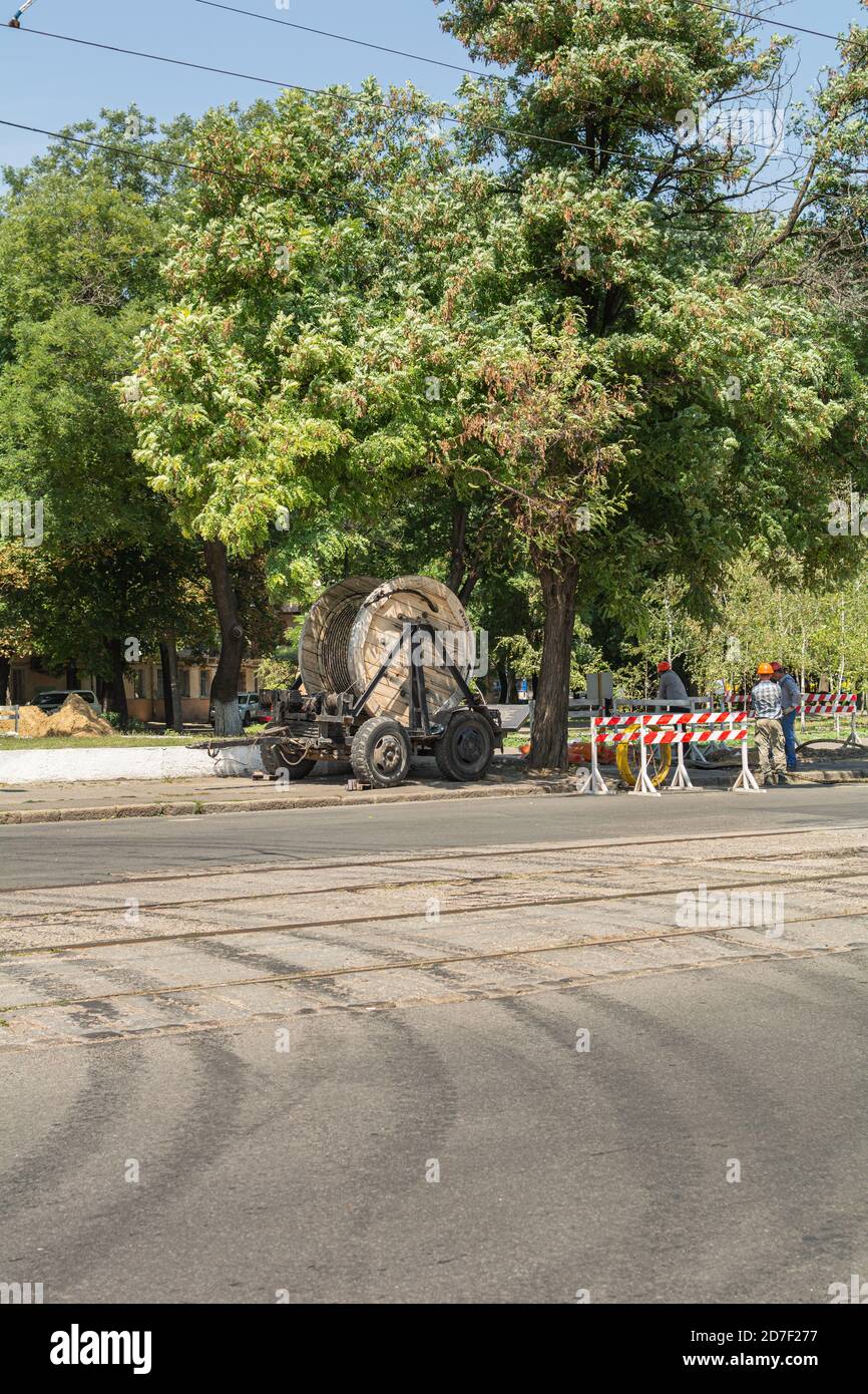 Odessa, Ukraine - 8 août 2019 : les travailleurs tirent un rouleau de câble haute tension Banque D'Images