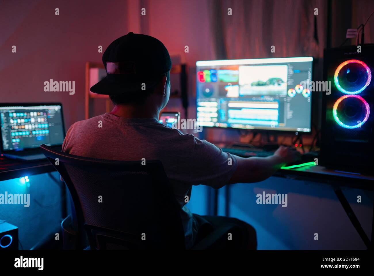 Blogueur travaillant à éditer des vidéos et regardant le moniteur au bureau à domicile tout en travaillant sur la post-production d'un fichier vlog Banque D'Images