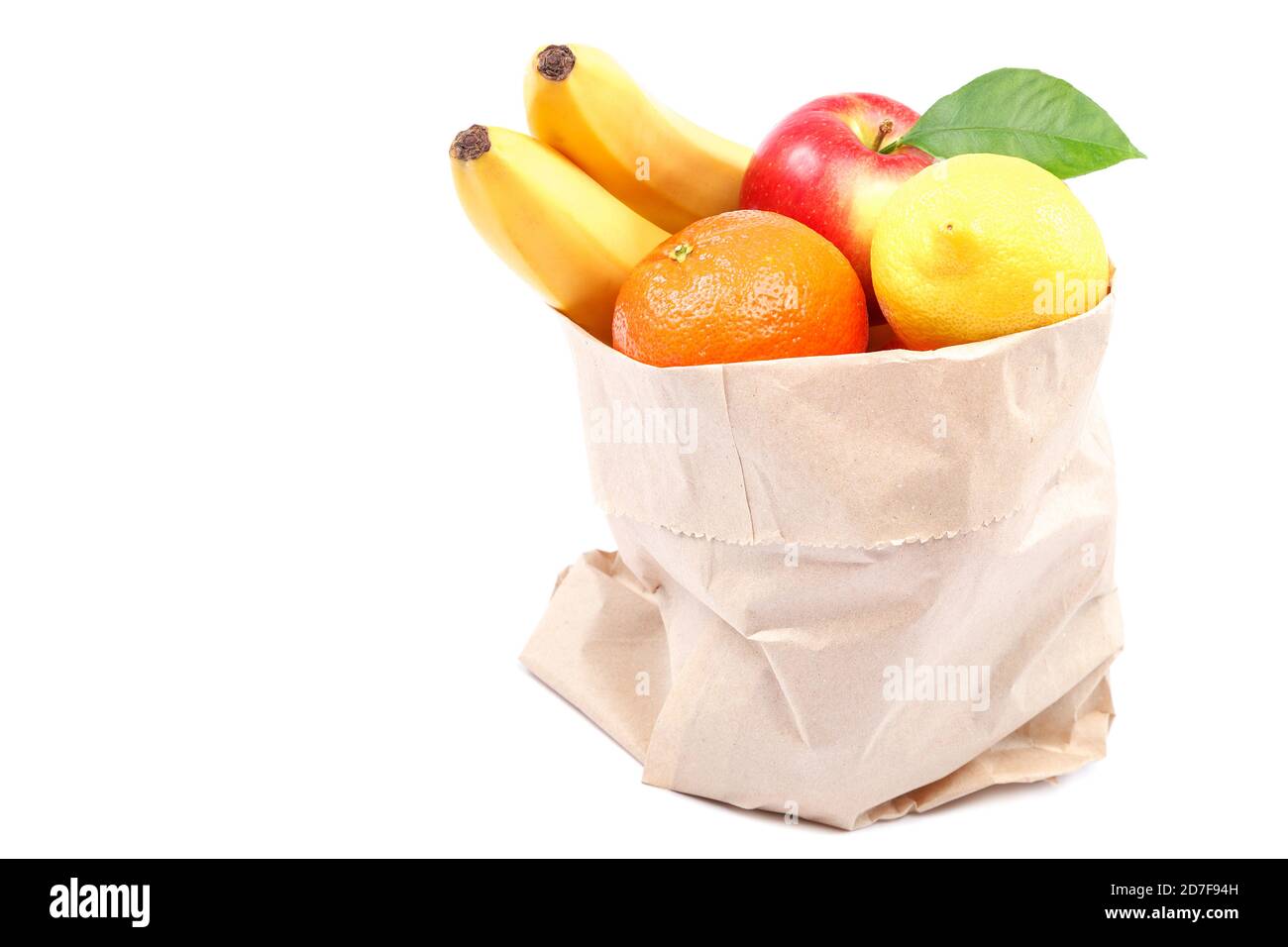 Bananes fraîches, citron, mandarines, pommes dans un sac en papier isolé sur fond blanc. Banque D'Images