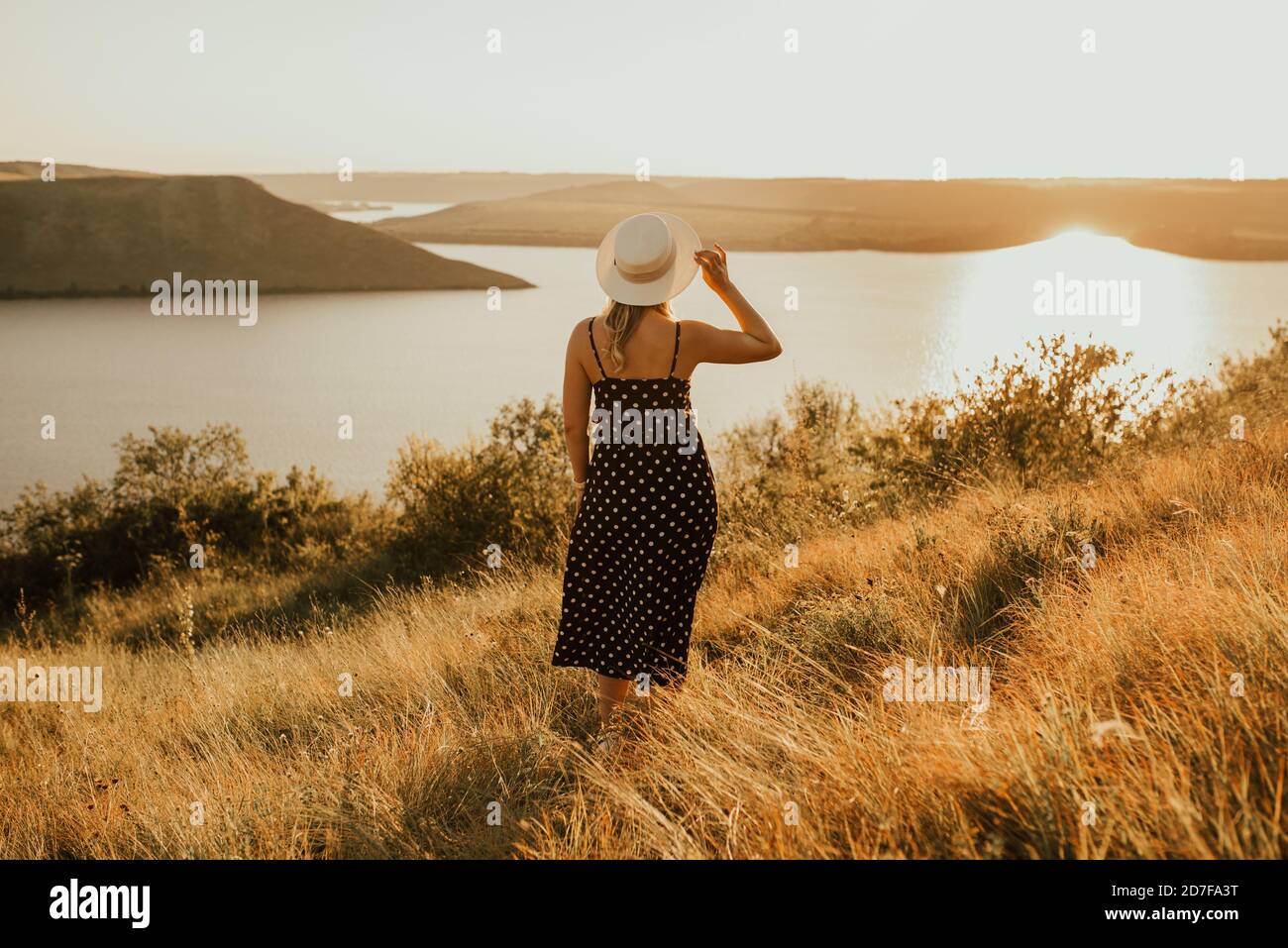 femme dans un chapeau au milieu de la prairie sur falaise au-dessus de la mer Banque D'Images