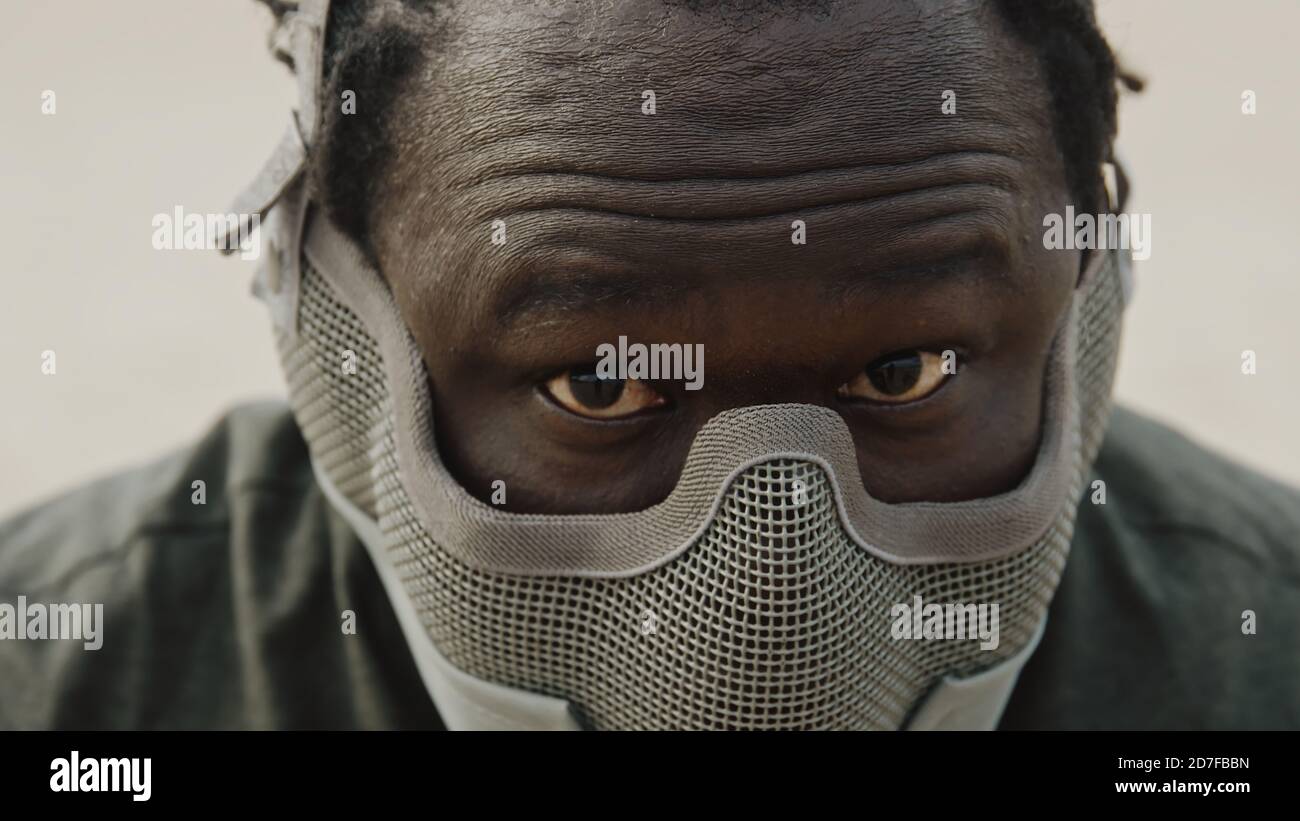 Gros plan, homme africain avec masque sur son visage secouant la tête prêt pour le combat. Photo de haute qualité Banque D'Images