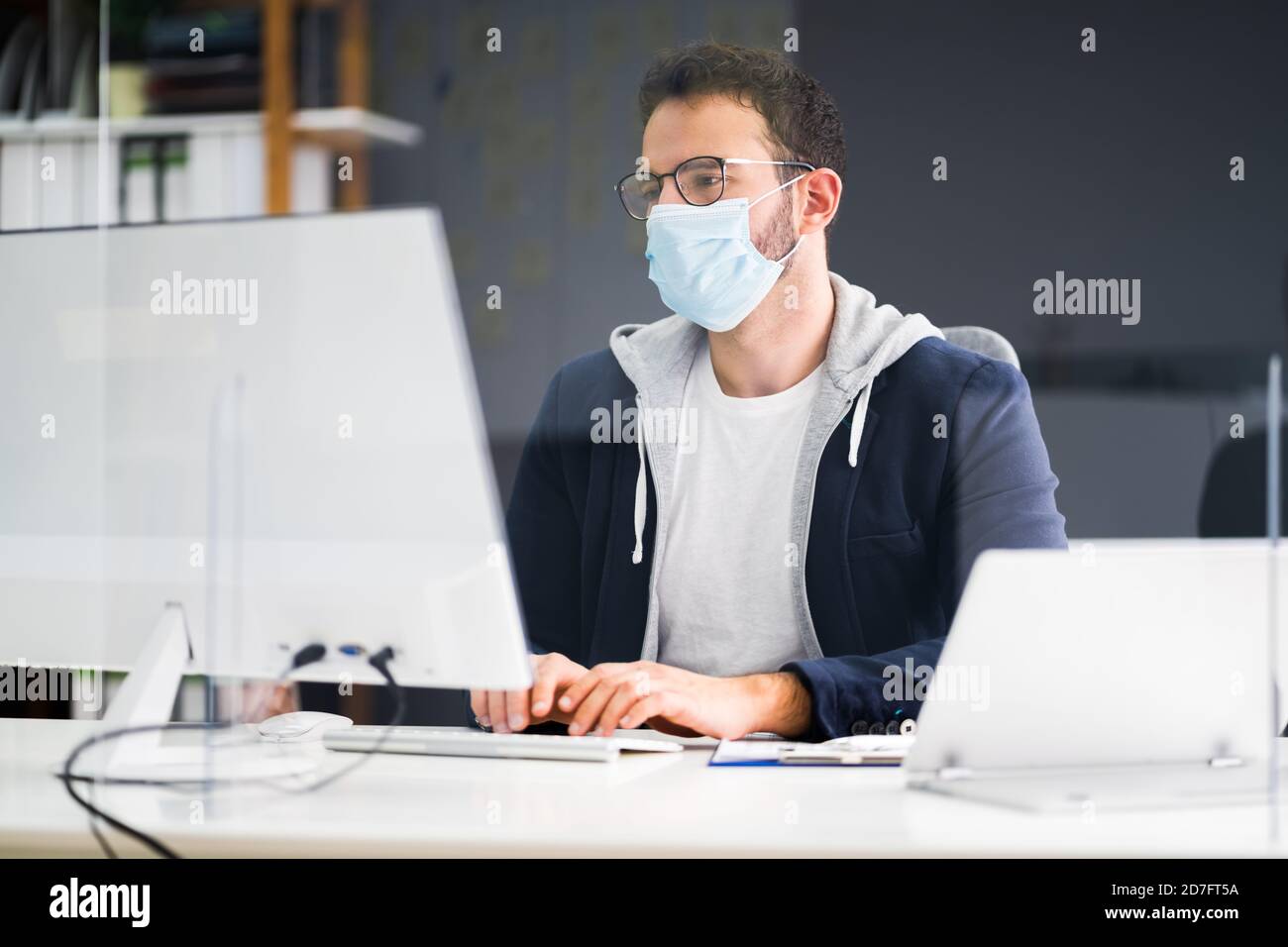 Employé d'entreprise portant un masque facial au bureau de l'ordinateur Banque D'Images
