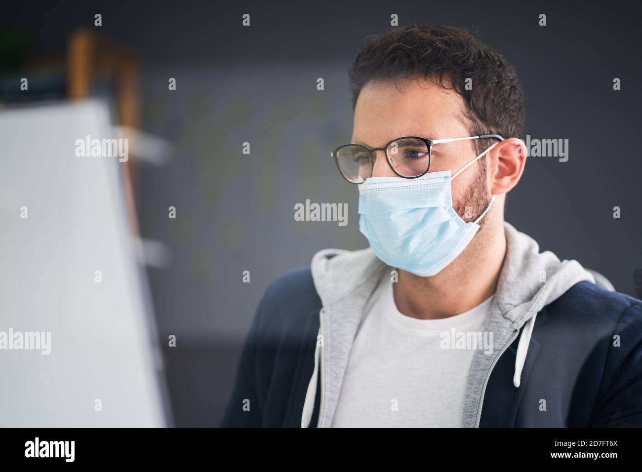 Employé d'entreprise portant un masque facial au bureau de l'ordinateur Banque D'Images