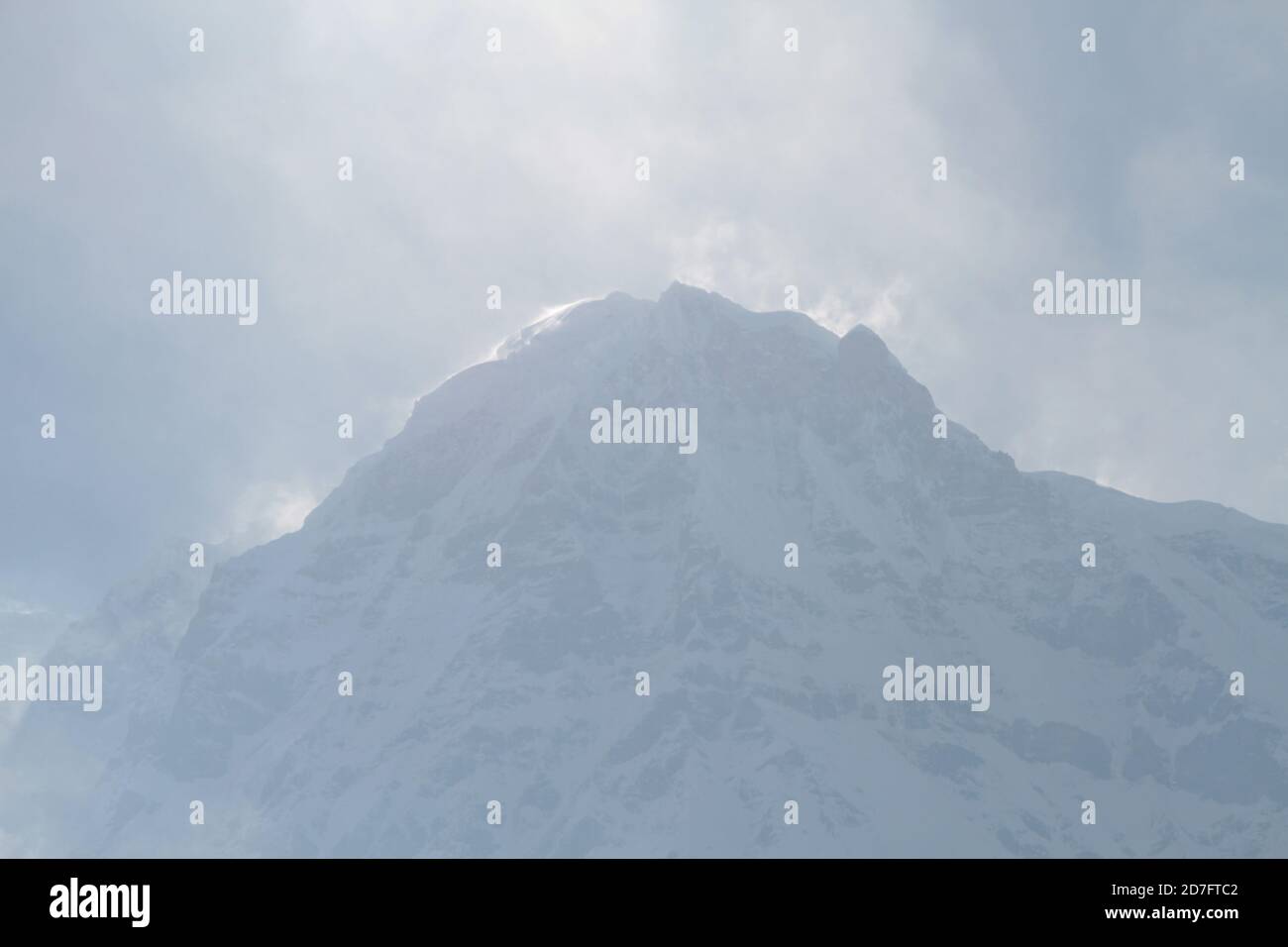 Photo majestueuse d'un massif rocheux enneigé de l'Annapurna avec des pics dans les nuages, au Népal, dans l'Himalaya Banque D'Images
