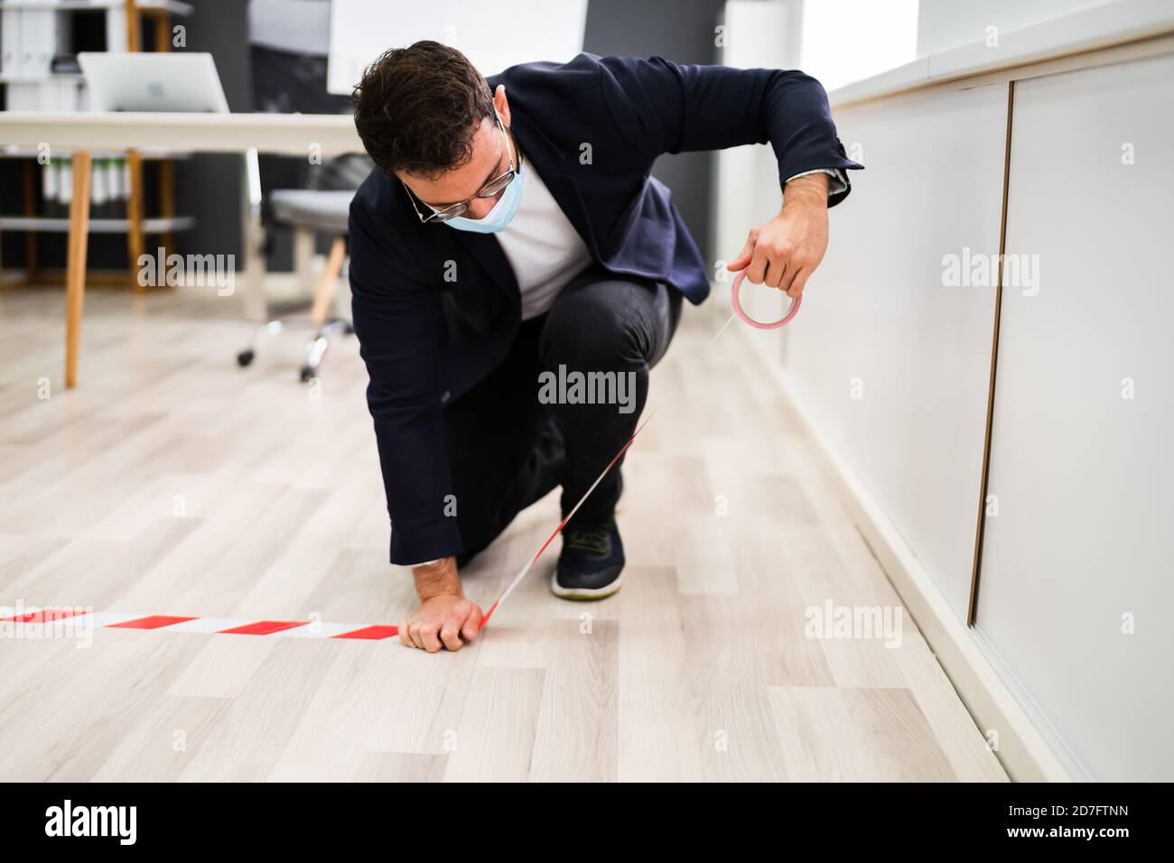 Employé de l'entreprise utilisant Red Tape Mark pour la prévention et les réseaux sociaux Distanciation au bureau Banque D'Images