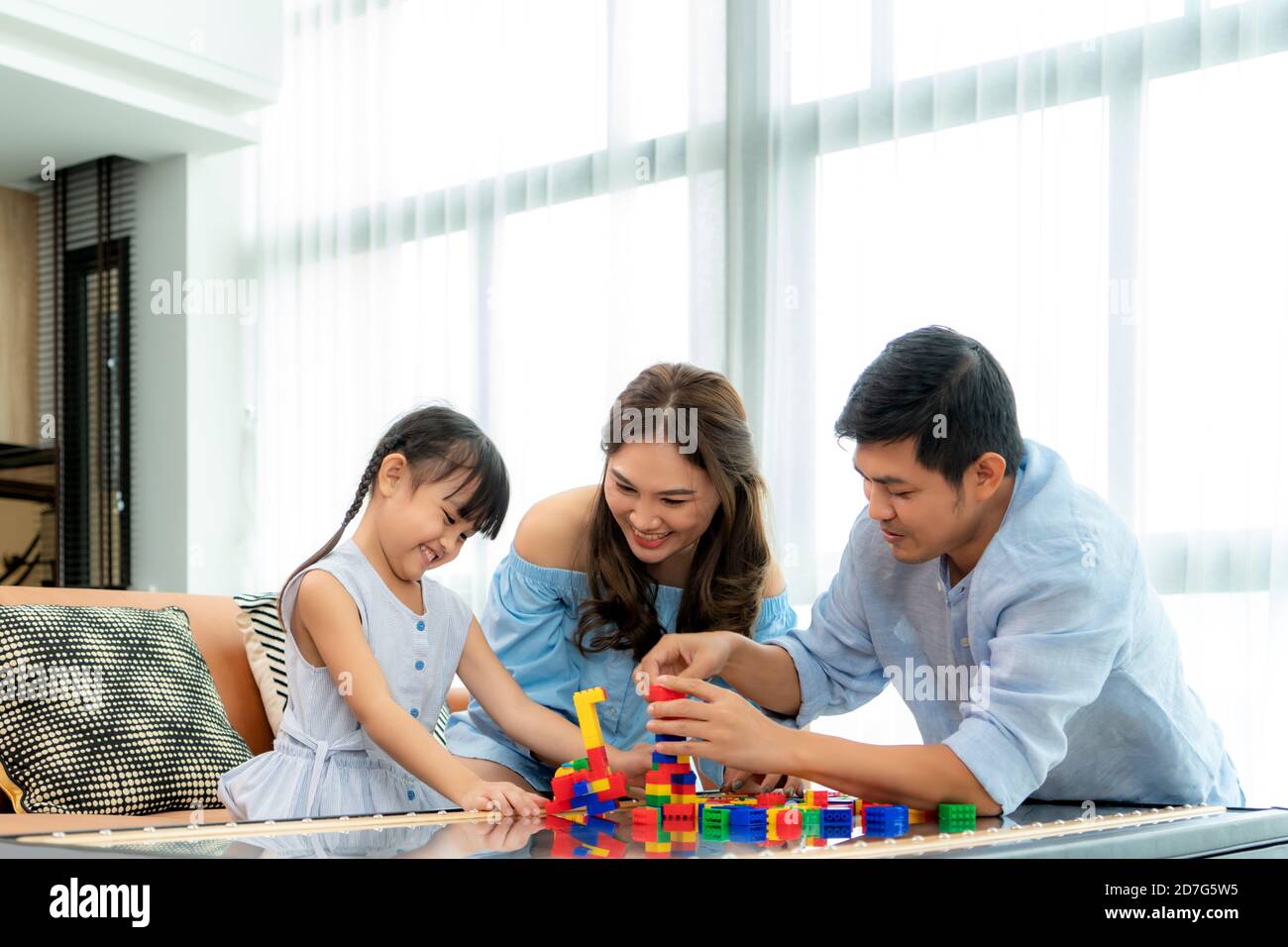 La famille asiatique passe du temps dans la salle de jeux avec son père, sa mère et sa fille avec des jouets sur le fond de la pièce, construit à partir de blocs en plastique dans la salle de séjour à la maison Banque D'Images