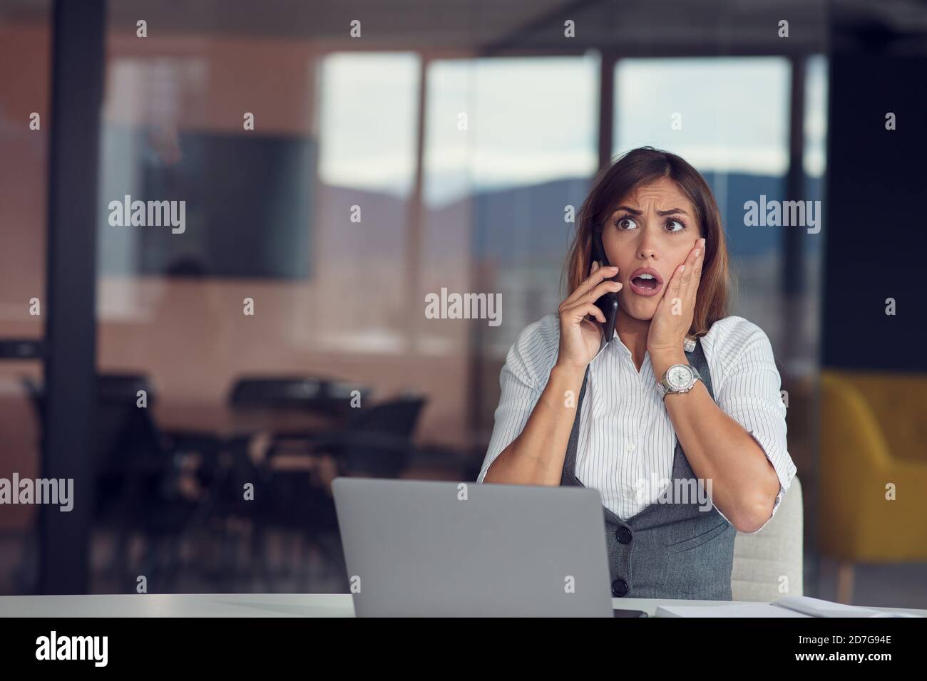 Une femme d'affaires en colère au téléphone dans un bureau moderne Banque D'Images