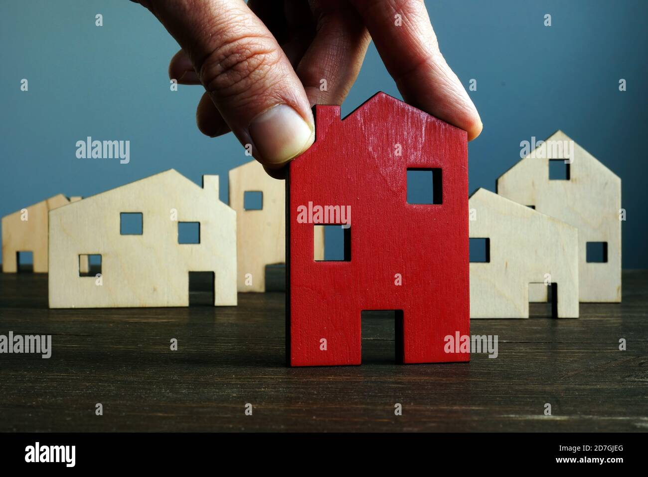 La main tient la maison. Choix de l'évaluation de biens ou de biens immobiliers. Banque D'Images