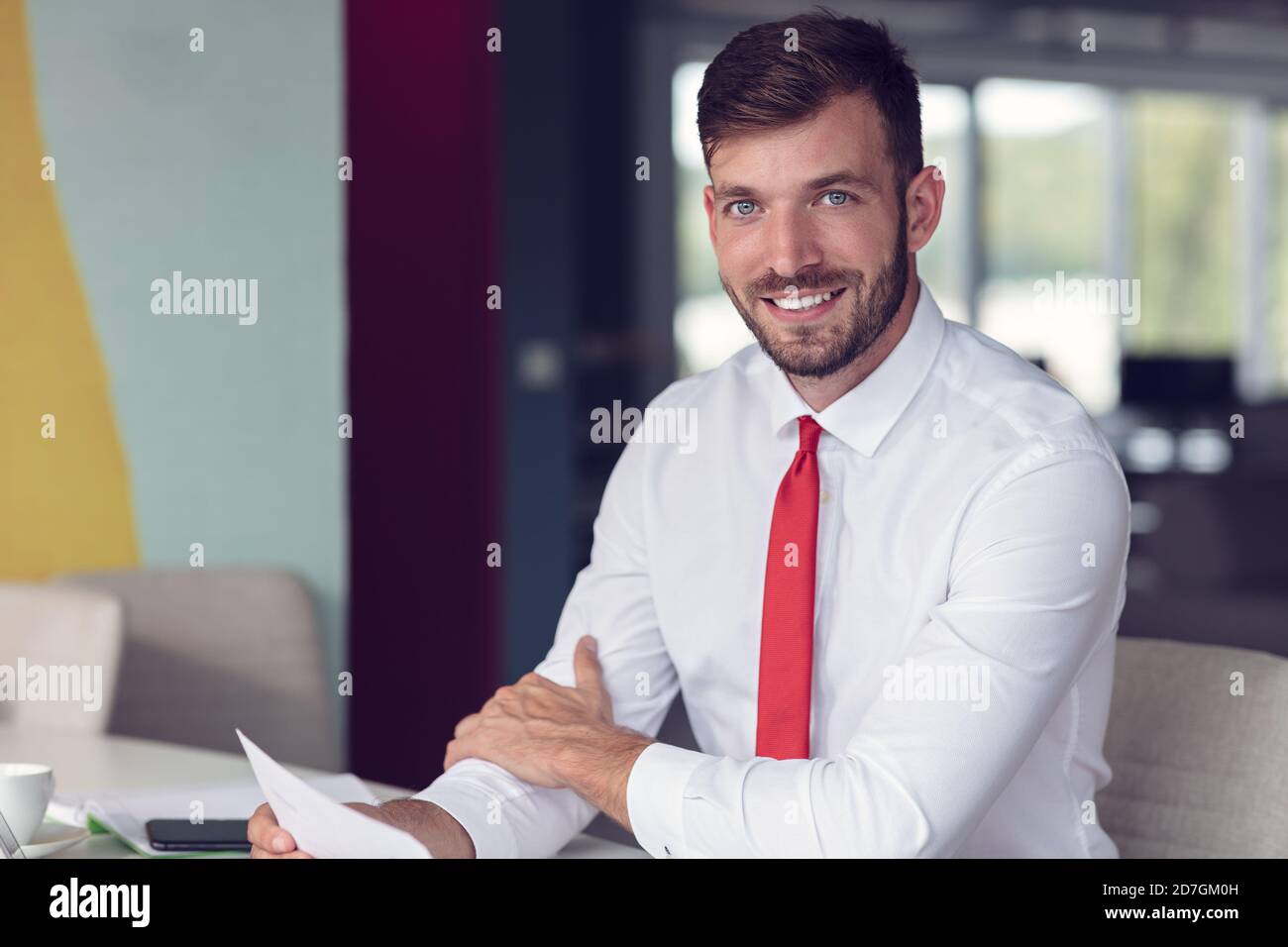 Portrait de jeune homme assis à son bureau dans le bureau Banque D'Images