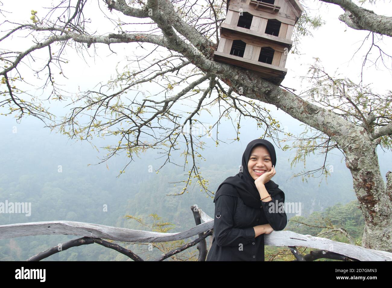 Portrait d'une femme asiatique avec une expression heureuse se posant sous une cage de pigeon. Profitez de vacances au sommet d'une colline le week-end. Banque D'Images