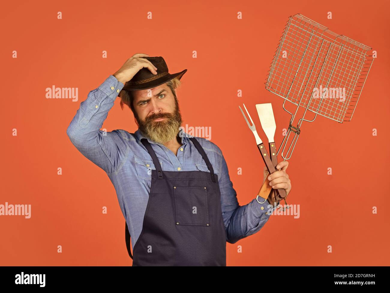 Dîner-fête. Le défi de la cuisine ultime. Préparez le dîner pour la famille. Utilisez des ustensiles de cuisine et divers produits. Le chef mûr utilise des ustensiles de cuisine pour le barbecue. Outils pour la torréfaction de viande. Qui cuisinent mieux. Banque D'Images