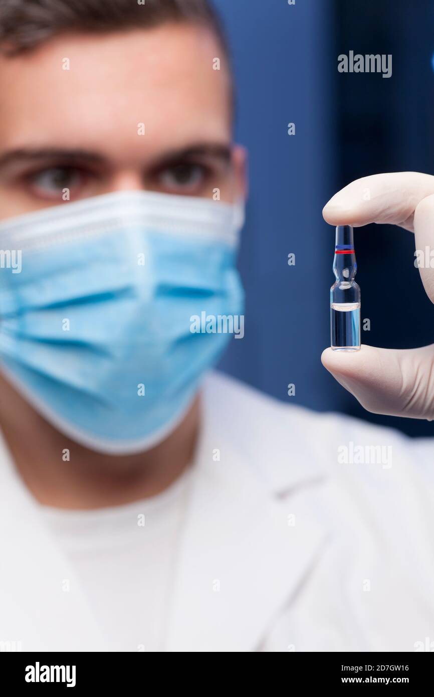 Médecin tenant une ampoule pour la vaccination ou le traitement de beauté dans sa main - se concentrer sur l'ampoule Banque D'Images