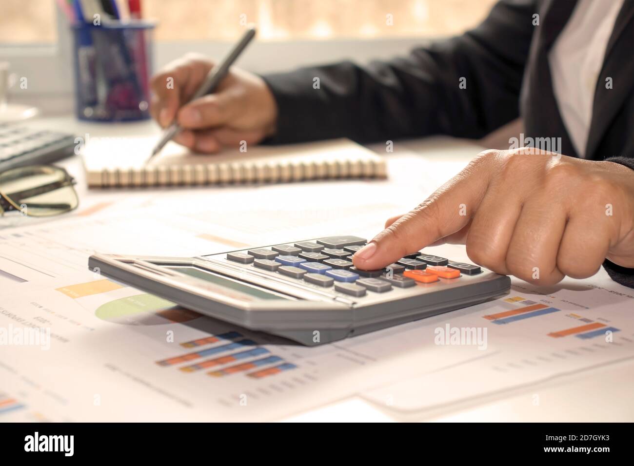 Gros plan d'hommes d'affaires ou de comptables tenant un stylo et appuyant sur la calculatrice pour calculer des informations d'affaires, des documents comptables, des affaires Banque D'Images