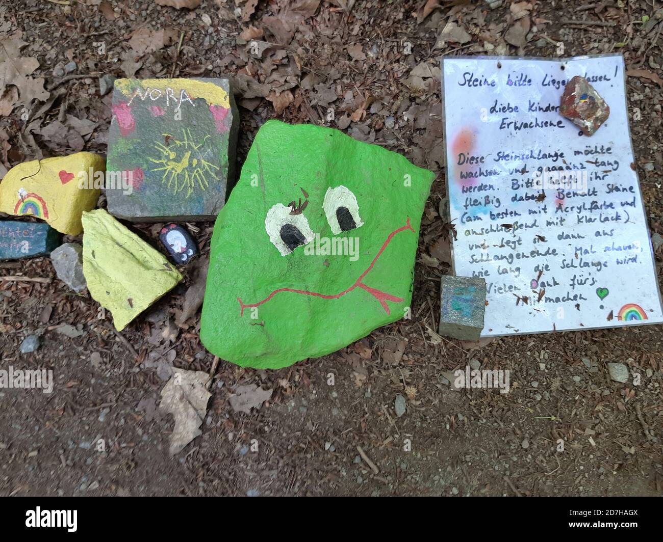 Pierres sur le côté de chemin peintes par des enfants avec des motifs naturels, Allemagne Banque D'Images