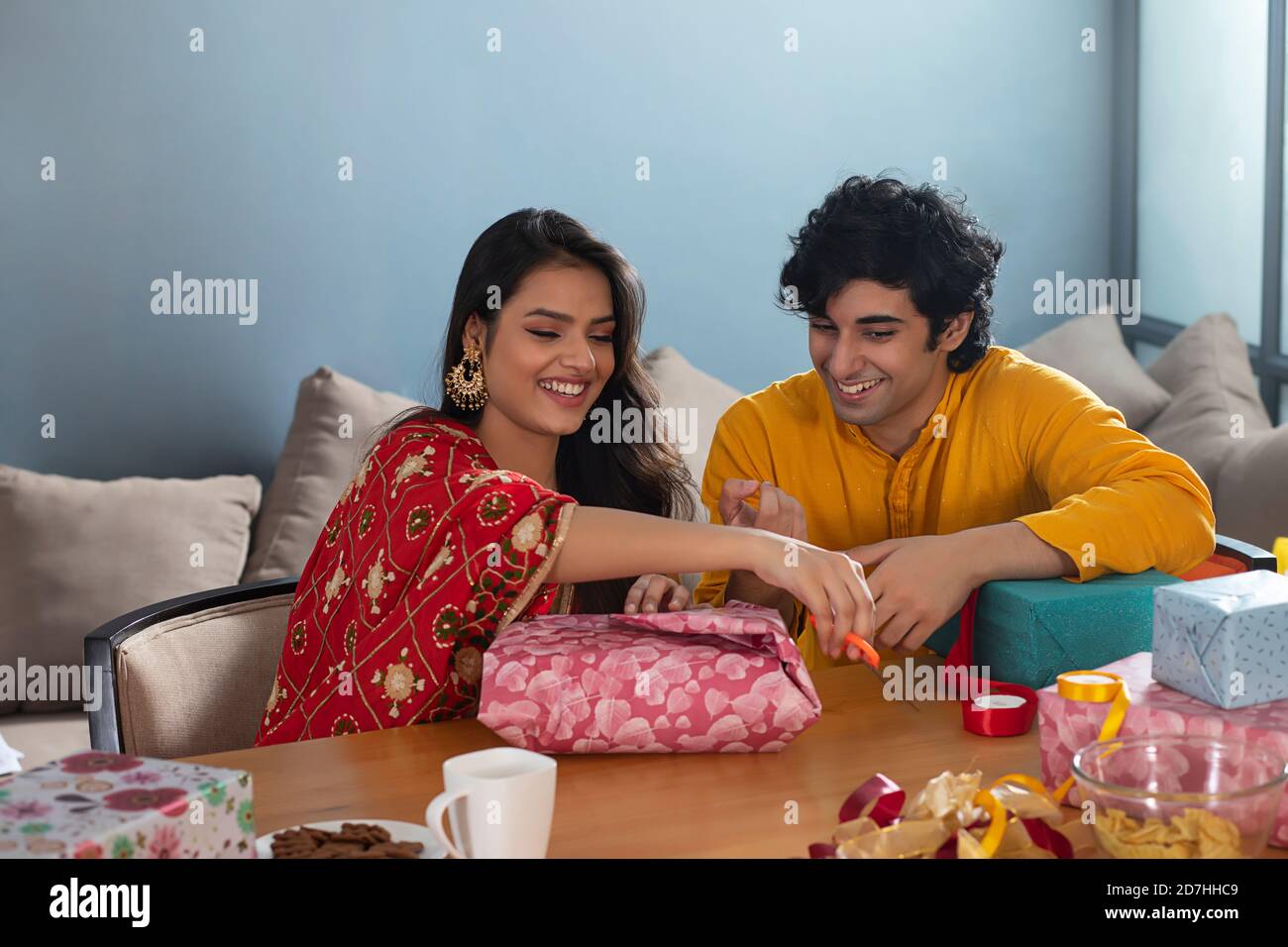 Un jeune couple parle et se regarde les uns les autres tout en emballant Un cadeau pour la fête de Diwali Banque D'Images