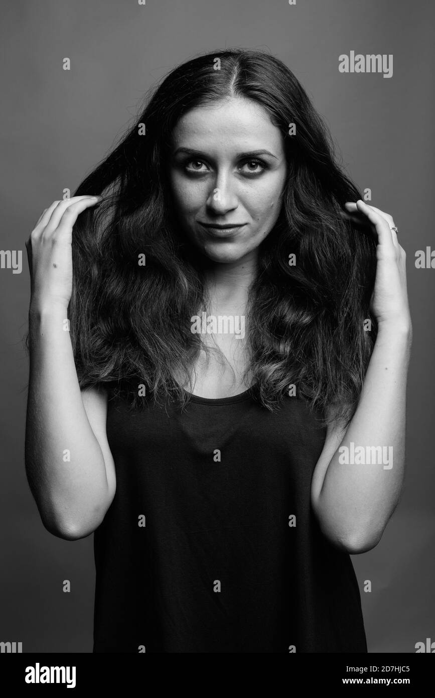 Belle jeune femme contre l'arrière-plan gris Banque D'Images