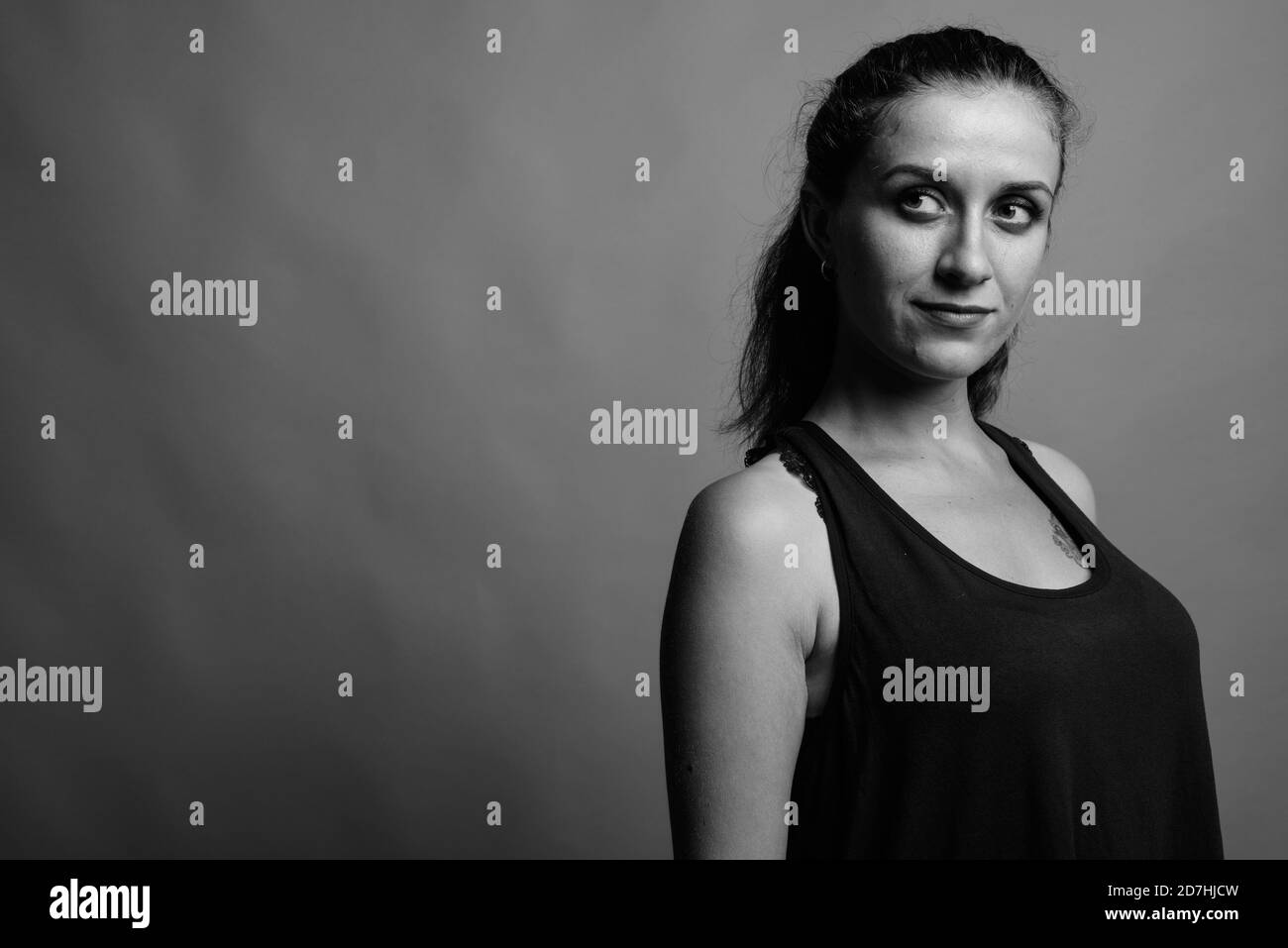 Belle jeune femme contre l'arrière-plan gris Banque D'Images