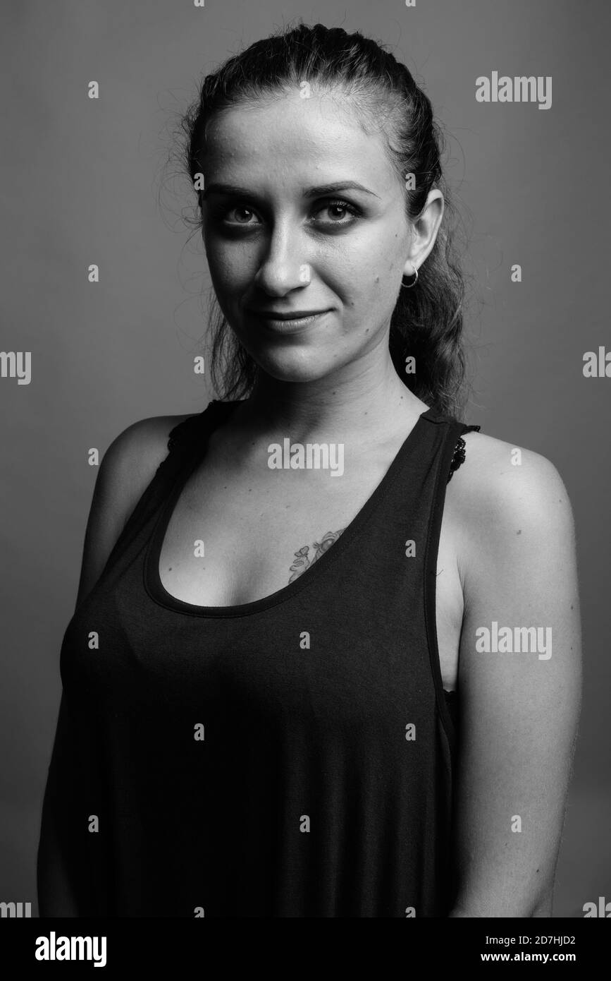 Belle jeune femme contre l'arrière-plan gris Banque D'Images