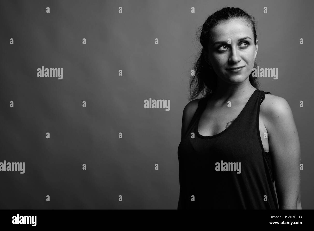 Belle jeune femme contre l'arrière-plan gris Banque D'Images