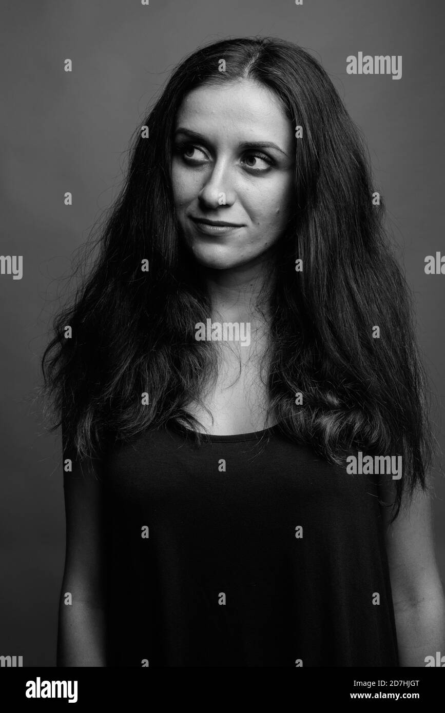 Belle jeune femme contre l'arrière-plan gris Banque D'Images