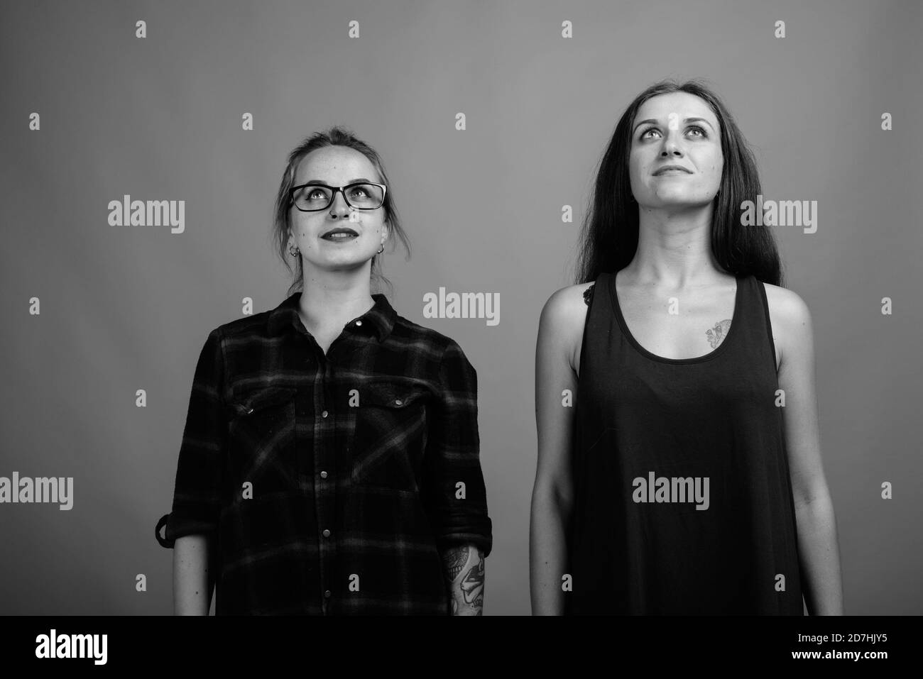 Deux jeunes belles amies sur fond gris Banque D'Images
