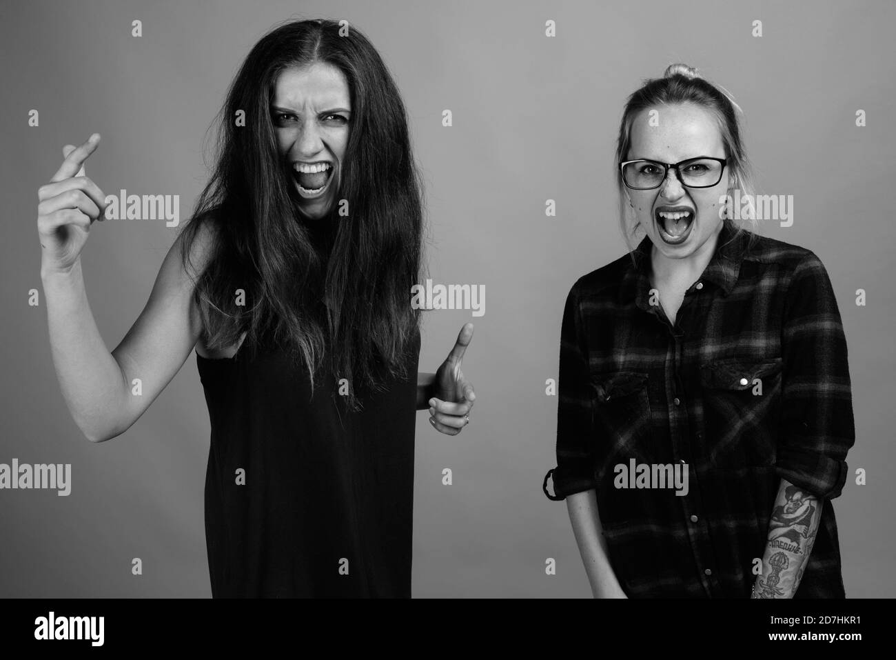 Deux jeunes belles amies sur fond gris Banque D'Images