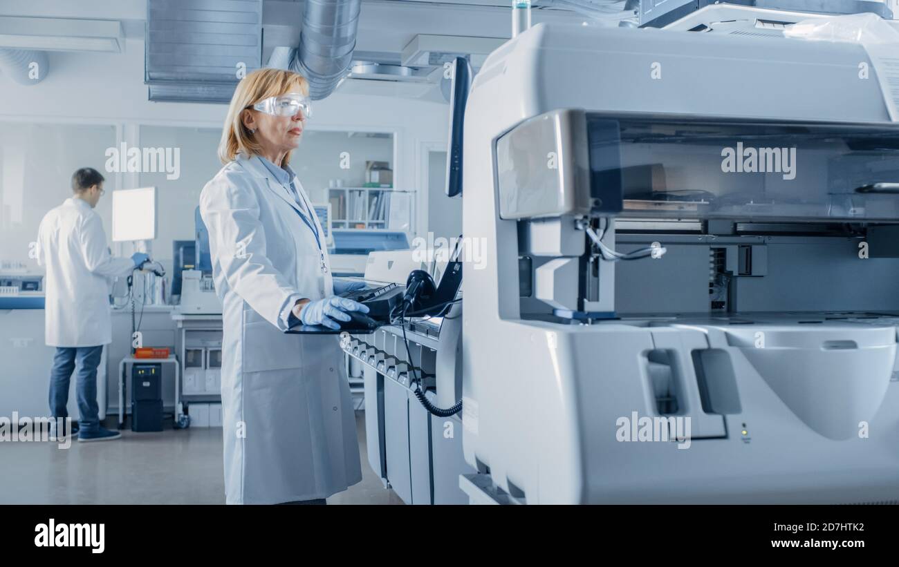 Femmes scientifiques programmes matériel médical avec ordinateur personnel. Équipe de professionnels travaillant dans le Laboratoire moderne de recherche pharmaceutique. Banque D'Images