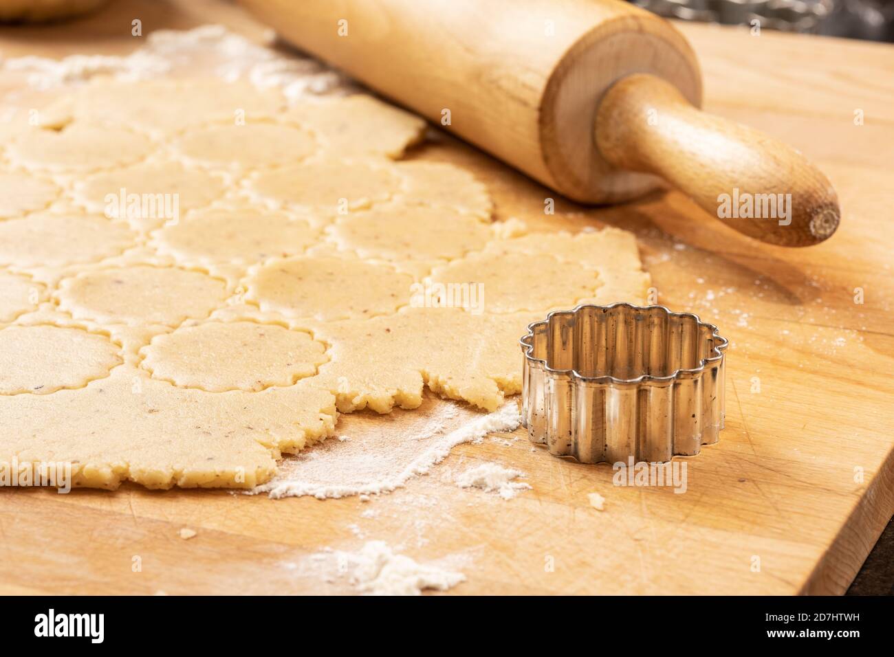 Boulangerie de Noël : un emporte-pièce, une pâte à croûte courte et un rollpin sur un plan de cuisine en bois. Banque D'Images