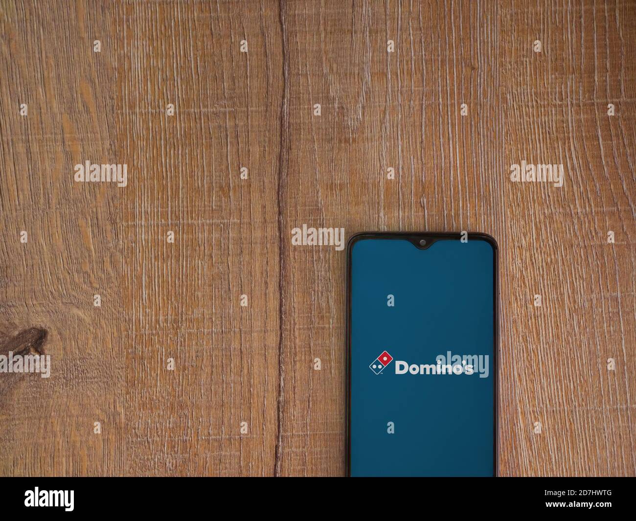 LOD, Israël - 8 juillet 2020 : écran de lancement de l'application Domino's Pizza Israel avec logo sur l'écran d'un smartphone mobile noir sur fond de bois. Haut vi Banque D'Images