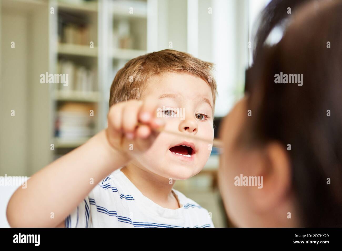 L'enfant joue avec la spatule lors de la consultation avec un pédiatre ou médecin de famille Banque D'Images