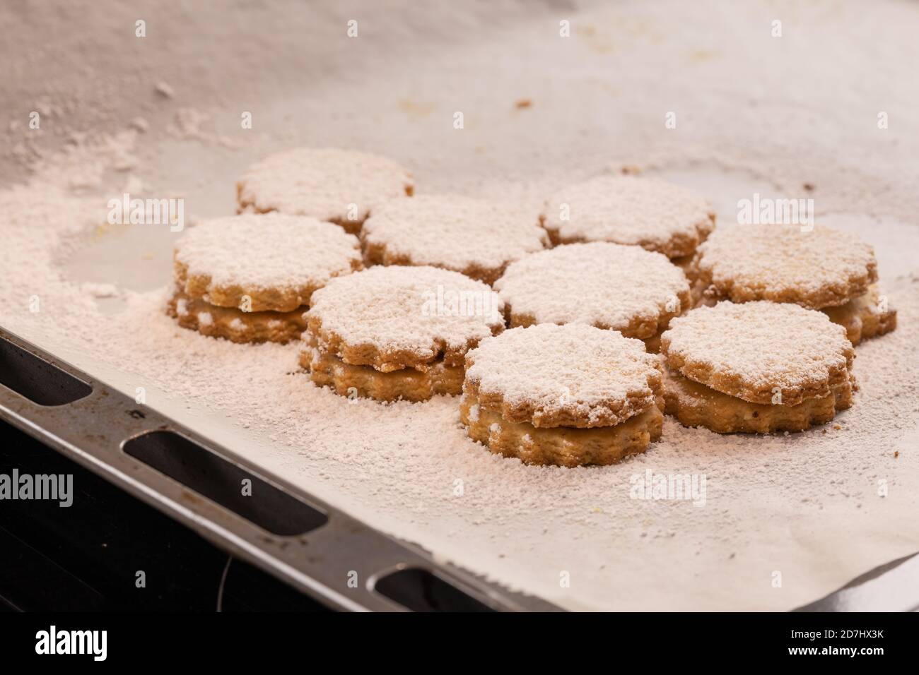 Cuisson de Noël : biscuits à la confiture allemande (Spitzbuben) avec glaçage au sucre sur le papier de cuisson Banque D'Images