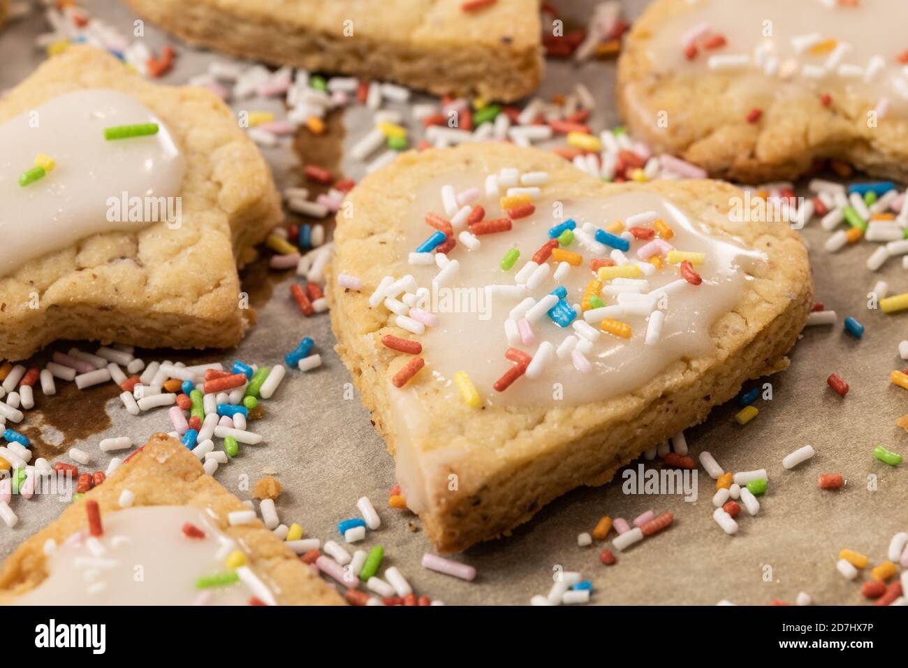 Cuisson de Noël : gros plan de biscuits à croûte courte avec glaçage au sucre sur du papier de cuisson Banque D'Images