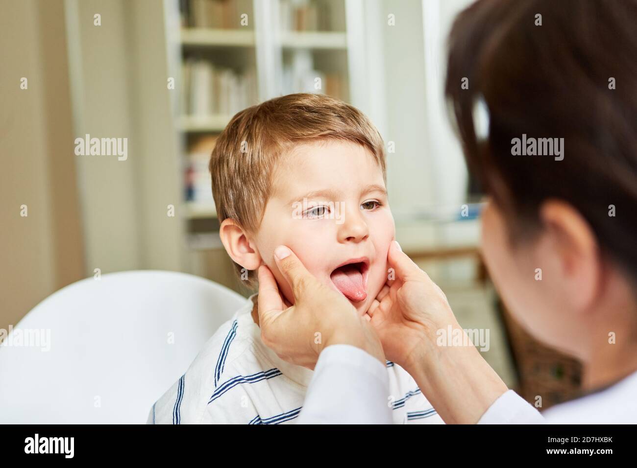 Le médecin de sexe féminin examine la gorge et la langue chez l'enfant atteint d'amygdalite ou mal de gorge Banque D'Images